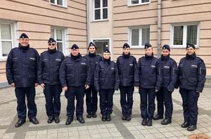 9 młodych policjantów na dziedzińcu komendy